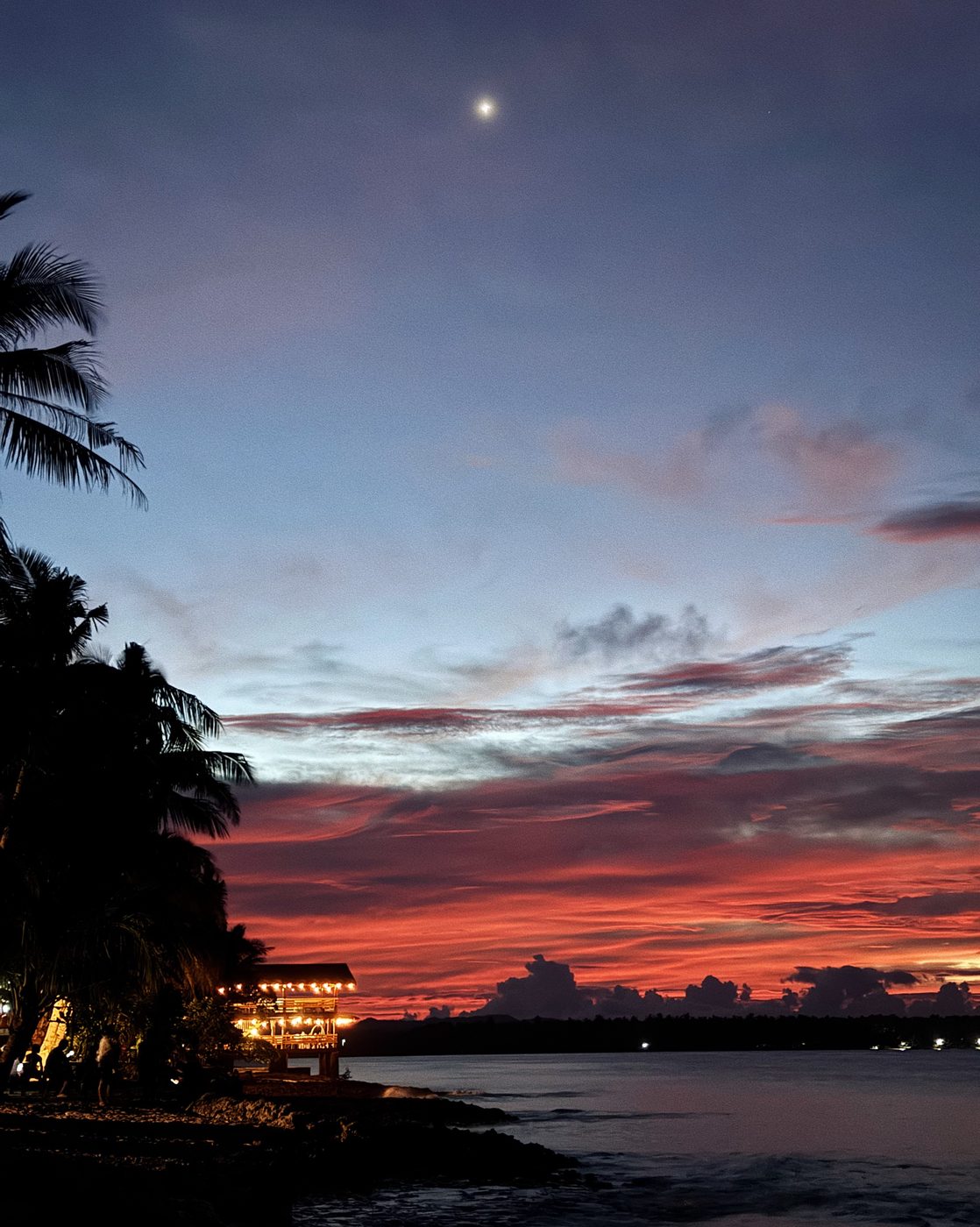 Siargao sunset over the sea with palm trees